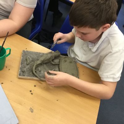Children making clay lizards
